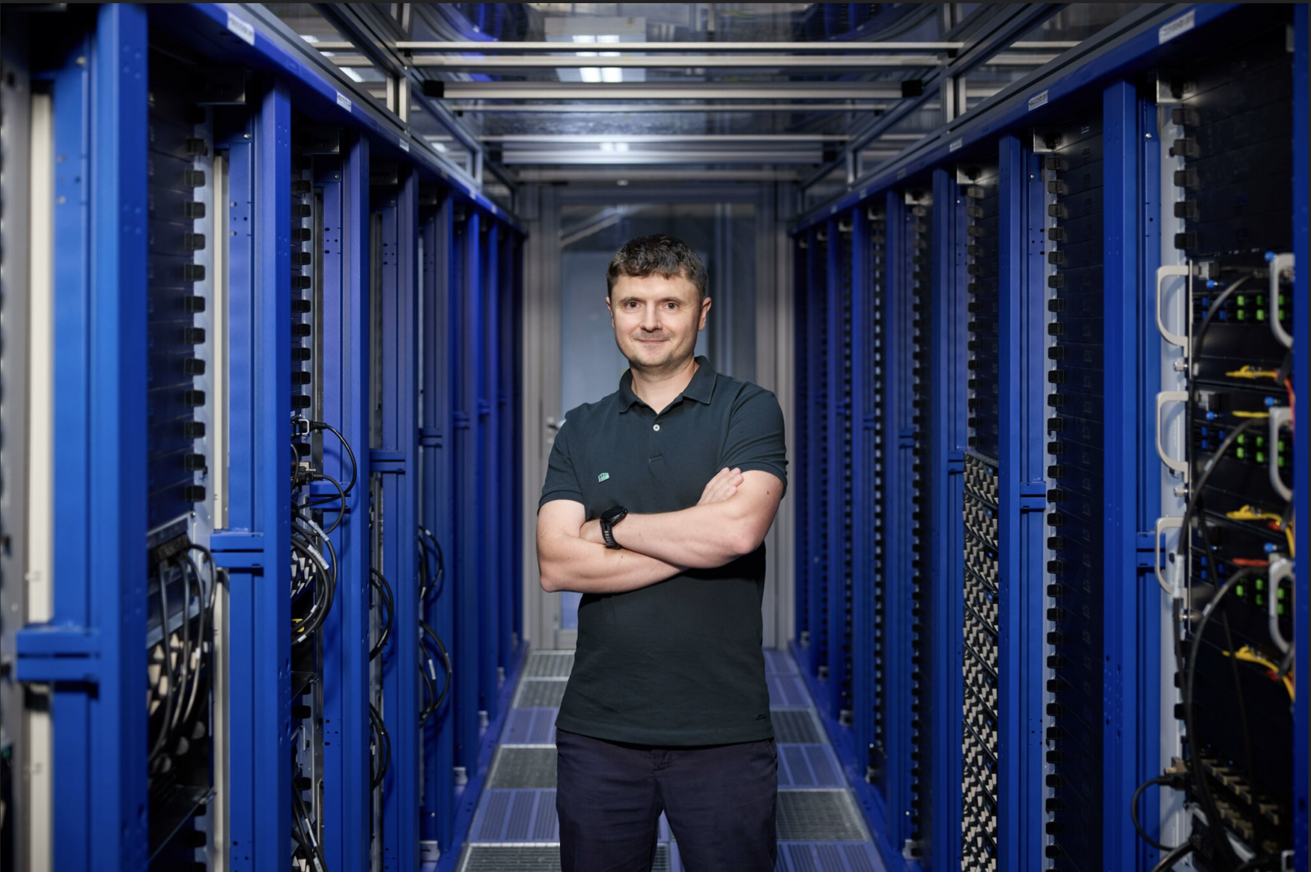 Dan Alistarsh standing amidst the rack in a datacenter. Photo credit: Johannes-Hloch