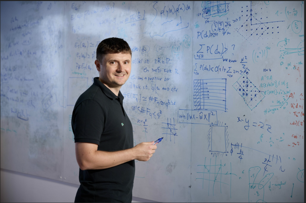 Dan Alistarh at a large whiteboard